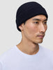 A person wearing a navy blue rib knit Wool Beanie Navy.