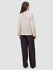 Back view of a person wearing a Women’s Chunky Soft Wool Knit Turtleneck Sugar Melange in an oversized, chunky knit style with dark wide-leg trousers.