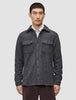 A man wearing a Double Layer Wool Overshirt Regular Dark Grey in a Scandinavian-design wool-blend with two chest pockets, layered over a white collared shirt.