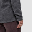 A person wearing a Double Layer Wool Overshirt Regular Dark Grey with long sleeves and brown trousers.