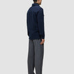 A person seen from behind wearing a Double Layer Wool Overshirt Regular Dark Navy, gray trousers, and dark shoes.