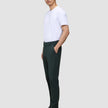 A person in a white t-shirt and dark green Ease Pants Regular Northern Pine stands in profile with one hand in their pocket.