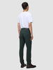 A man seen from behind wearing a white t-shirt, Ease Pants Regular Northern Pine, and brown leather shoes.