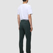 A man seen from behind wearing a white t-shirt, Ease Pants Regular Northern Pine, and brown leather shoes.