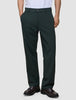 A person wearing exceptionally soft, dark green Ease Pants Relaxed Fit Northern Pine trousers and brown loafers.