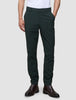 A person wearing exceptionally soft, slim-fit dark green Ease Pants Slim Northern Pine and brown leather boots.