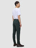 A person viewed from behind, wearing a white t-shirt, Ease Pants Slim Northern Pine, and dark leather boots.