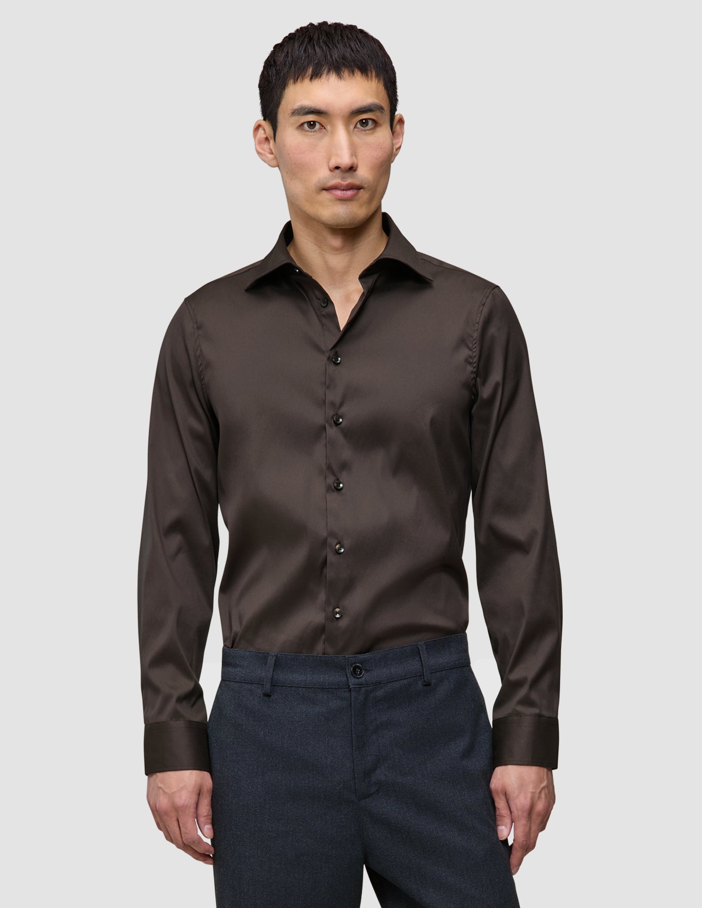 A man wearing an Elevated Shirt Regular Dark Brown, featuring a long-sleeved button-down design with a Scandinavian-inspired aesthetic.