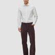 A man wearing an Elevated Shirt Regular Light Grey Striped button-up shirt, dark brown trousers, and black loafers.