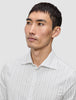 A man wearing an Elevated Shirt Regular Light Grey Striped, a white dress shirt featuring thin, light grey vertical stripes.