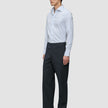 A man wearing an Elevated Shirt Slim Classic Blue Striped light blue striped slim fit shirt, dark trousers, and black dress shoes.