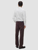 A person seen from behind wears an Elevated Shirt Slim Light Grey Striped, tucked into dark brown trousers and dark leather shoes.