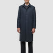 A man wearing a dark grey Maxi Wool Coat Dark Grey over a dress shirt, tie, and black trousers.