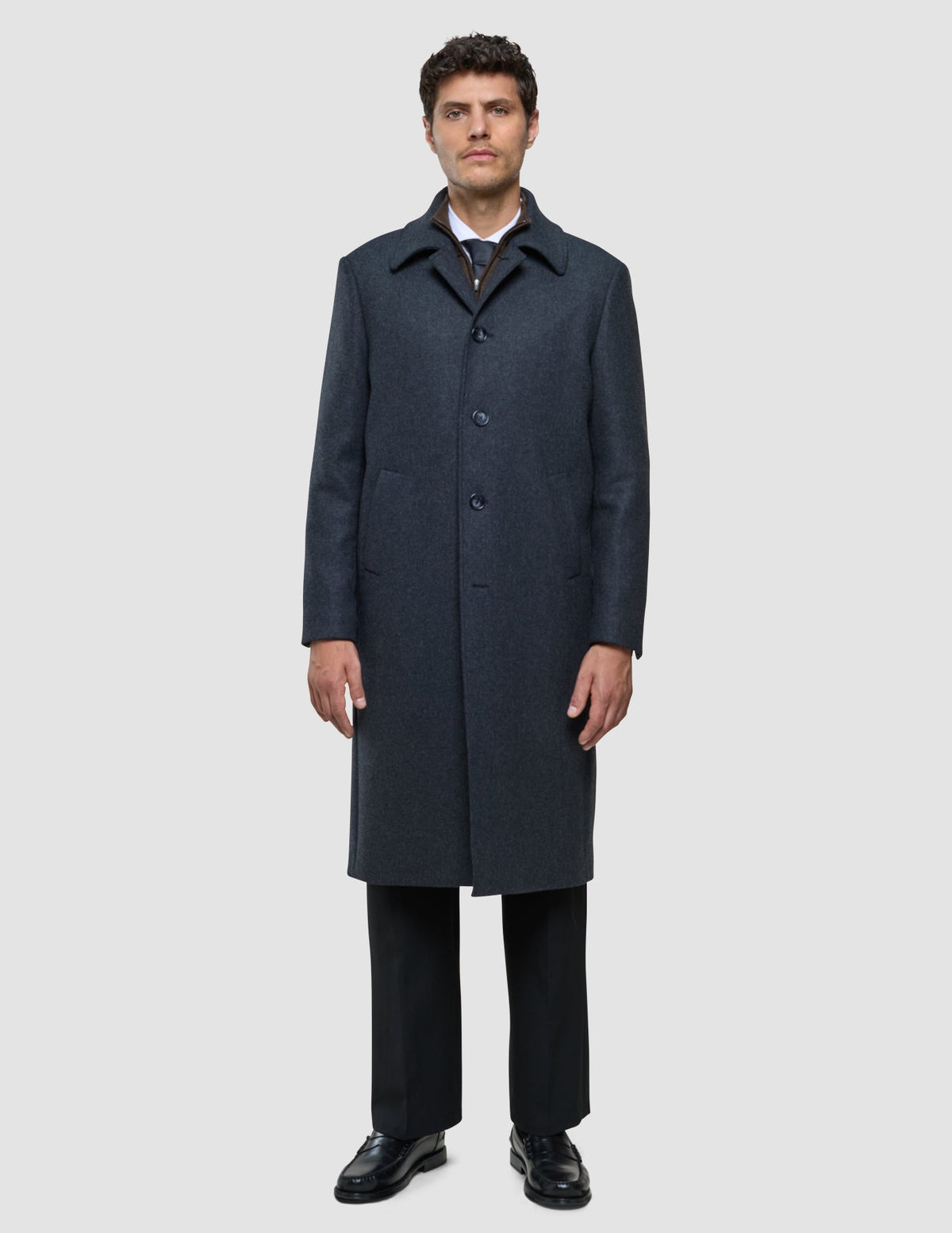 A man wearing a dark grey Maxi Wool Coat Dark Grey over a dress shirt, tie, and black trousers.