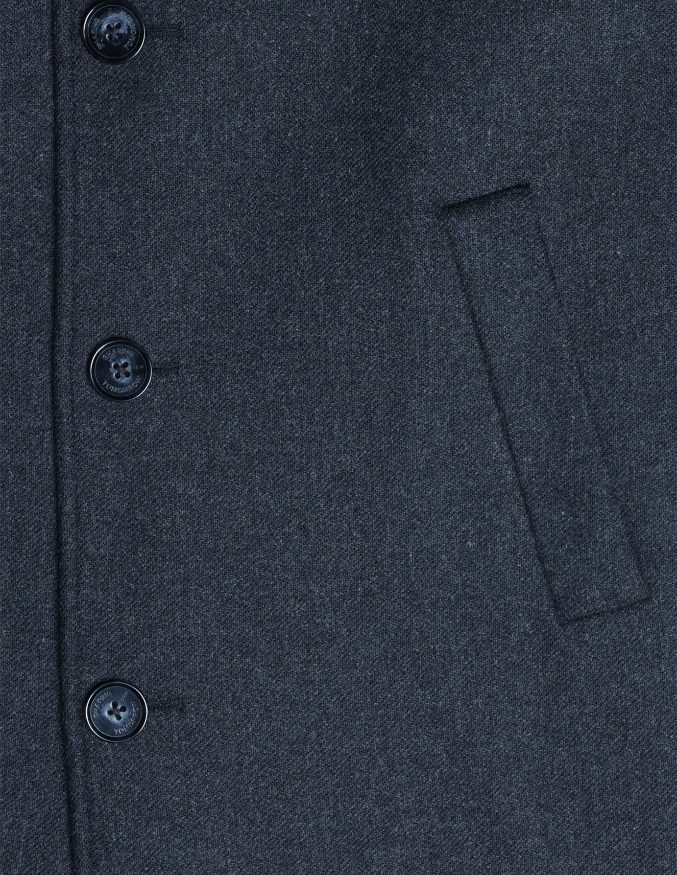Close-up of a Maxi Wool Coat Dark Grey, featuring three buttons and a vertical welt pocket on its tailored dark grey wool fabric.