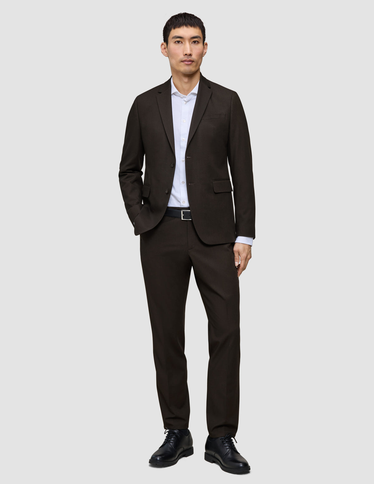 A man wearing a Motion Blazer Slim Cognac, white dress shirt, and black leather shoes.