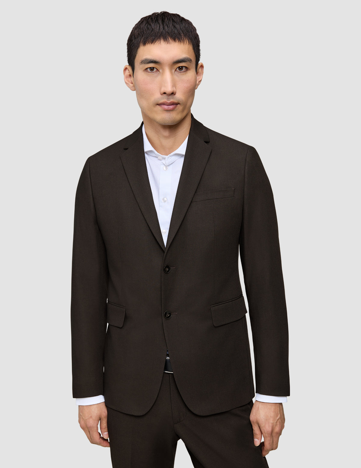 A man wearing a dark brown Motion Blazer Slim Cognac tailored over a white collared shirt.