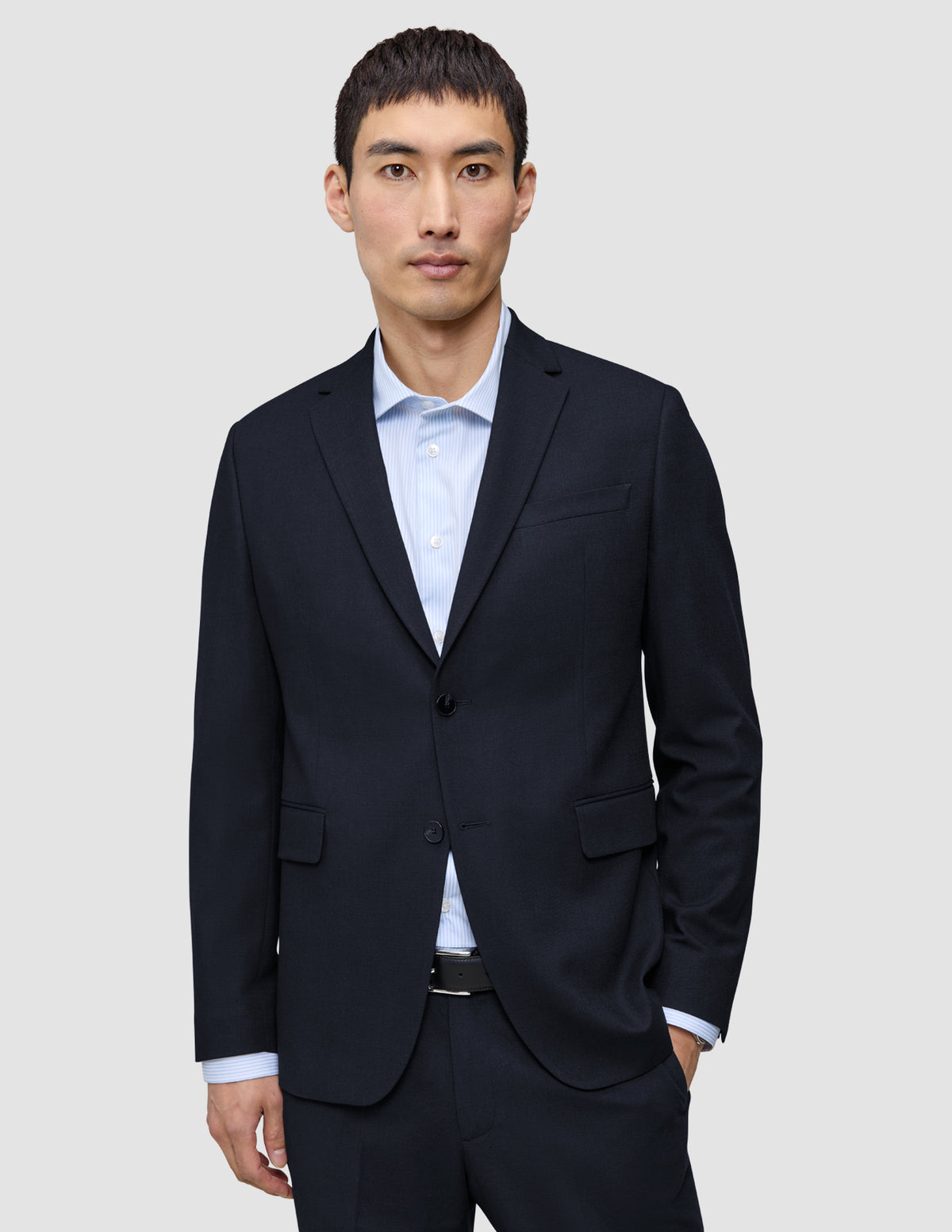 A man wearing a Motion Blazer Slim Midnight Blue over a light blue striped dress shirt.