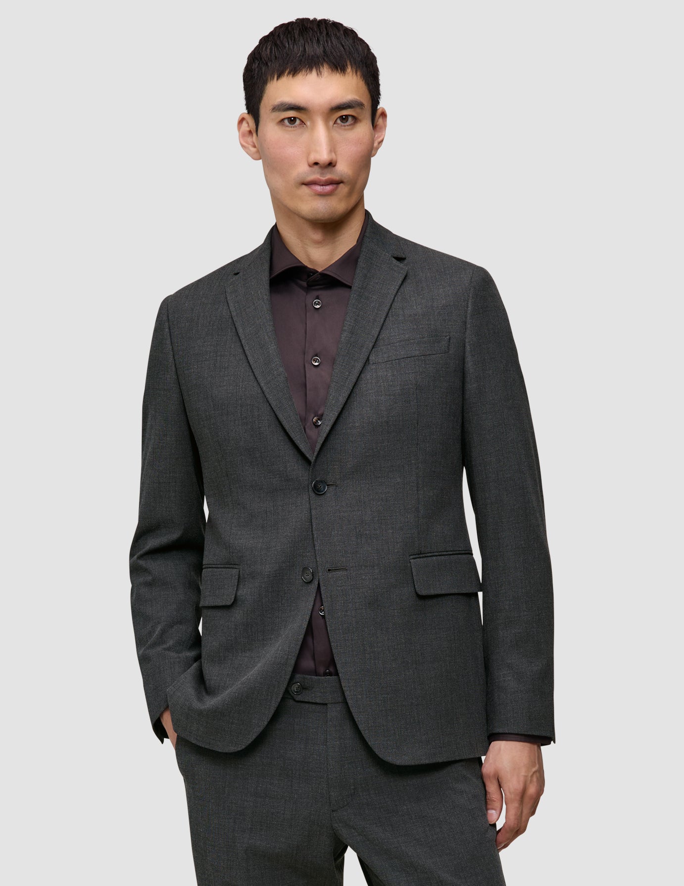 A man wearing a lightweight, breathable Motion Blazer Slim Pepper Grey over a dark button-down shirt.