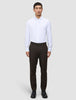 A man wearing a white button-down shirt, Motion Suit Pants Regular Cognac, and black dress shoes.
