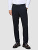 A man wearing a white dress shirt, Motion Suit Pants Regular Midnight Blue, and dark brown loafers.