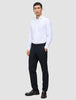 A man in a white button-down shirt and Motion Suit Pants Regular Midnight Blue stands with his hand in his pocket.