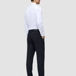 A man viewed from behind, wearing a white button-down shirt and Motion Suit Pants Regular Midnight Blue with his hands in his pockets.