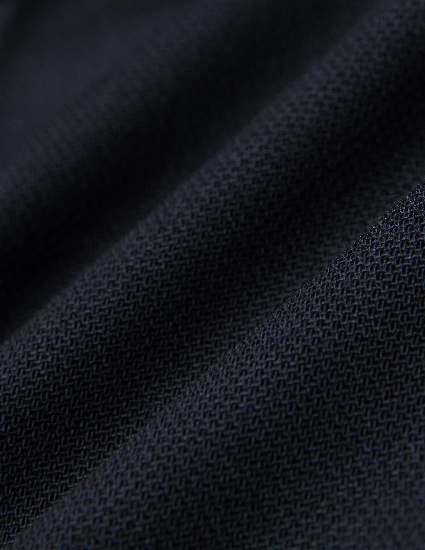 Close-up of Motion Suit Pants Regular Midnight Blue featuring lightweight, dark blue fabric with a visible, breathable woven texture and subtle folds.