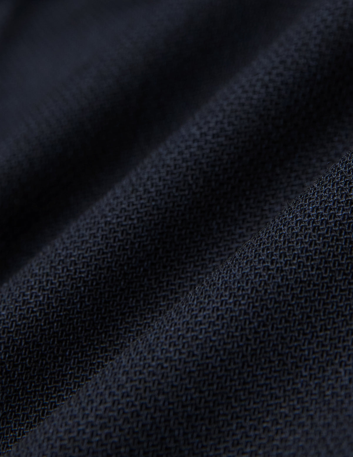 Close-up of Motion Suit Pants Regular Midnight Blue featuring lightweight, dark blue fabric with a visible, breathable woven texture and subtle folds.