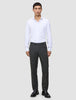 A man wearing a white button-down shirt, Motion Suit Pants Regular Pepper Grey, and black dress shoes.