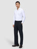 A man wearing a white button-down shirt and Motion Suit Pants Relaxed Midnight Blue, paired with dark brown loafers.