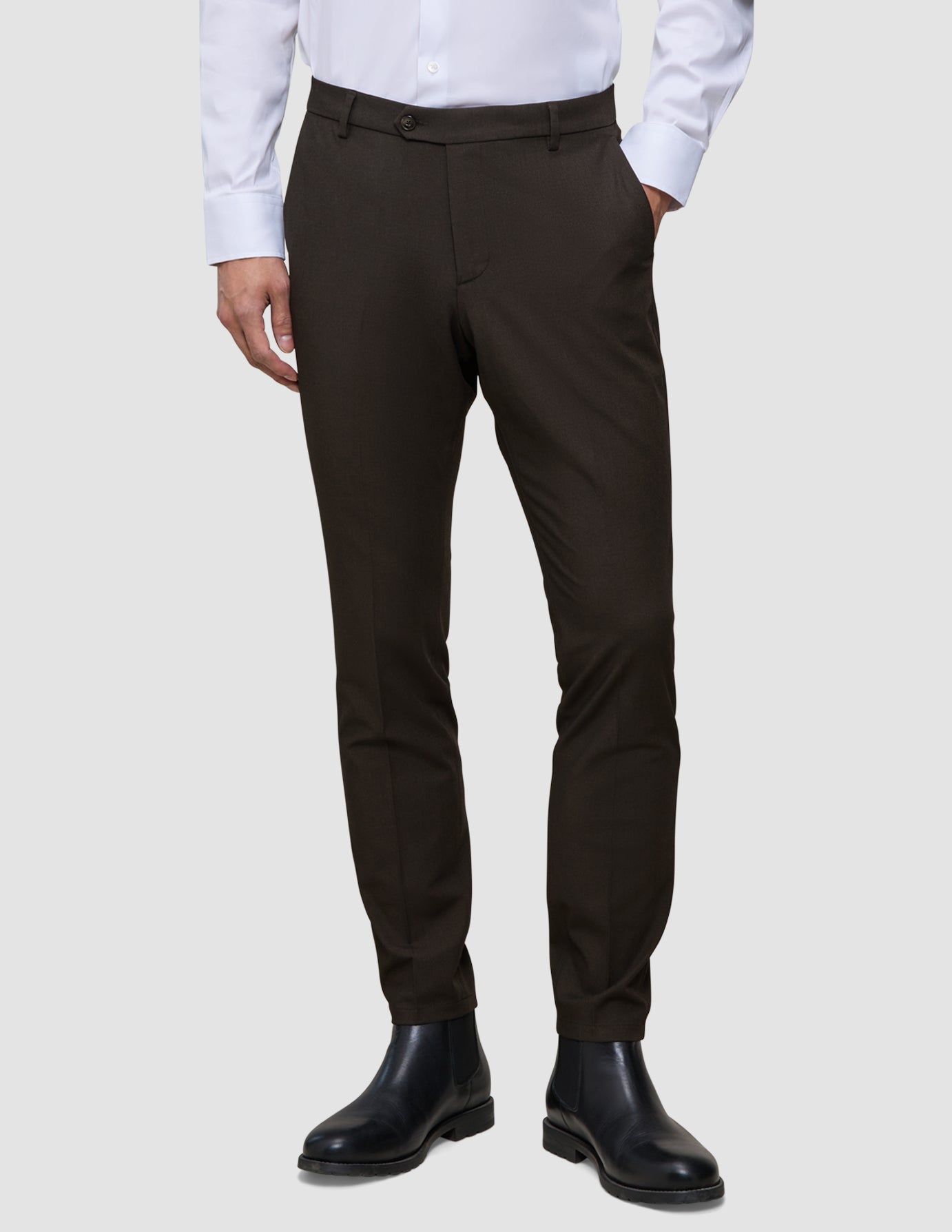 Slim-fit 360° stretch Motion Suit Pants Slim Cognac paired with a white button-down shirt and black boots.