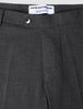 Close-up of the waistband and top of dark grey Motion Suit Pants Slim Pepper Grey, featuring a single button closure, 360° stretch slim-fit, and an interior brand label reading Shaping New Tomorrow.