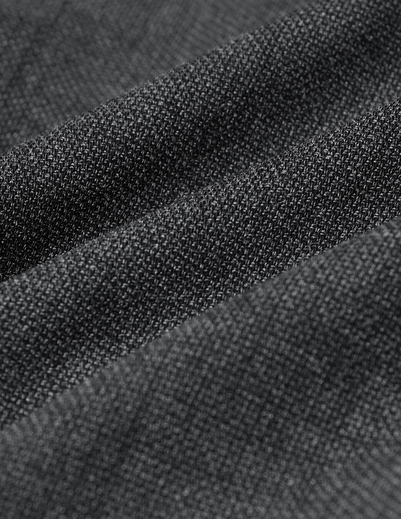 Close-up of Motion Suit Pants Slim Pepper Grey, featuring a grey, textured, knit-like fabric with a 360° stretch.