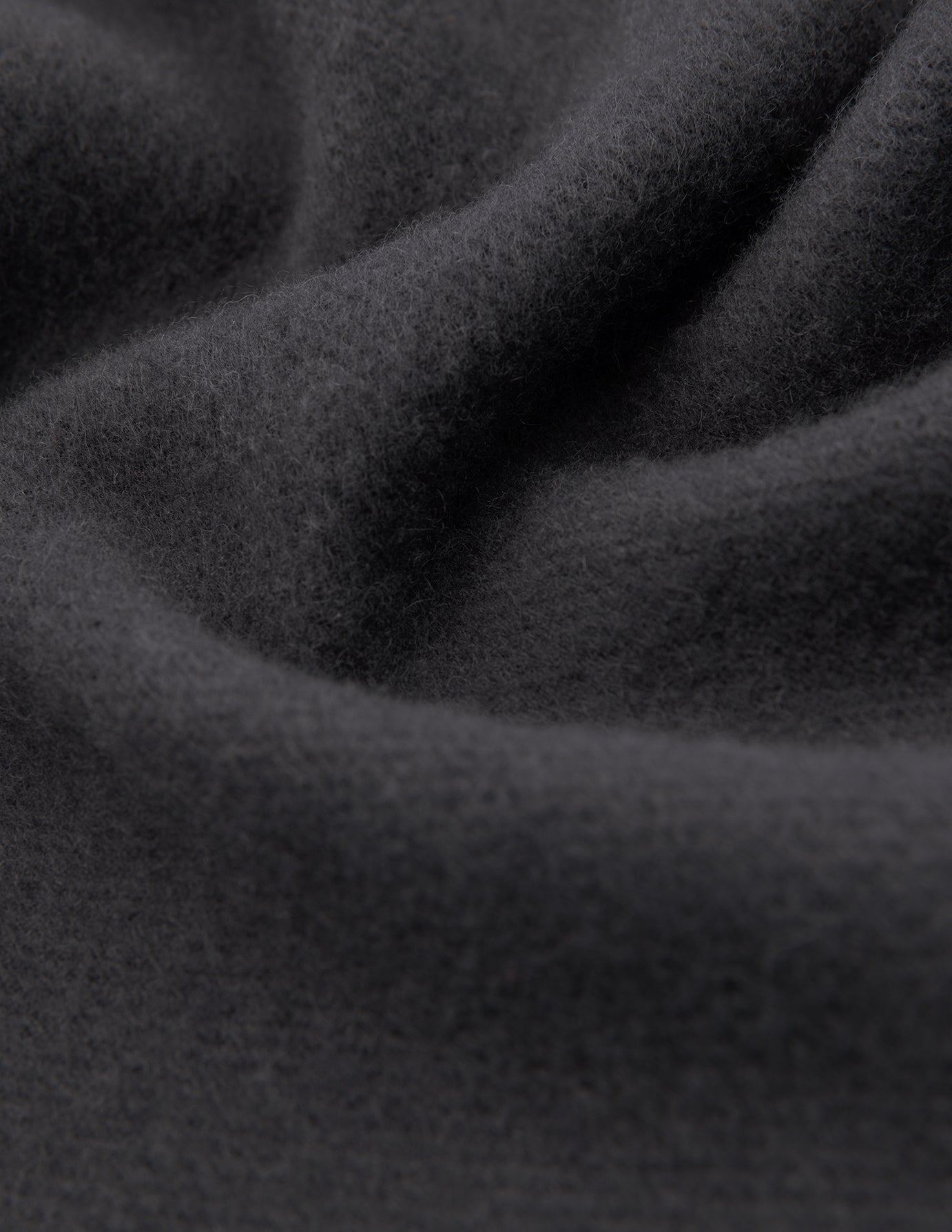 Close-up of a Scarf Charcoal Grey in soft, deep folds of cashmere.