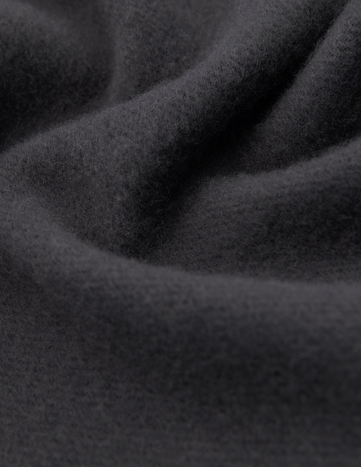 Close-up of a Scarf Charcoal Grey in soft, deep folds of cashmere.