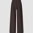 Serene Pants Wide Walnut Herringbone, featuring a dark brown Scandinavian design, wide-leg cut, high waist, thin vertical pinstripes, and a single button closure.