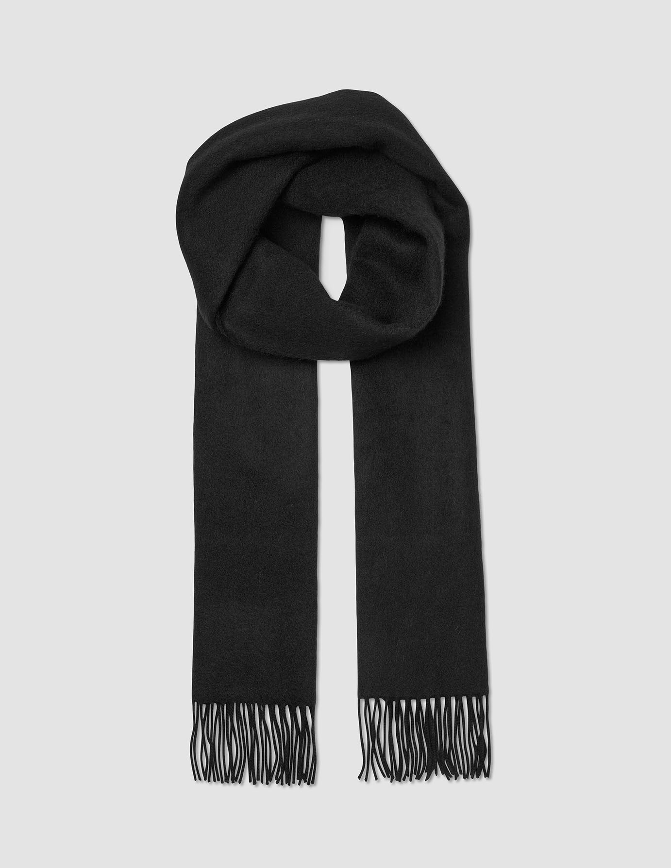 A black Merino knit scarf from A different kind of suit, with fringed ends and looped once at the top.