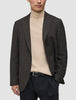 A person wearing a Timeless Wool Blazer Slim Dark Brown Check over a beige turtleneck sweater and black trousers.