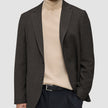 A person wearing a Timeless Wool Blazer Slim Dark Brown Check over a beige turtleneck sweater and black trousers.