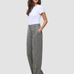 Woman wearing a white t-shirt and grey Women Ashryn Pants Wide Domino Herringbone featuring a high-waisted, wide-leg silhouette.