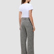 A woman seen from behind, wearing a white t-shirt and grey Women Ashryn Pants Wide Domino Herringbone with a high-waisted, wide-leg silhouette and a subtle herringbone bouclé texture.