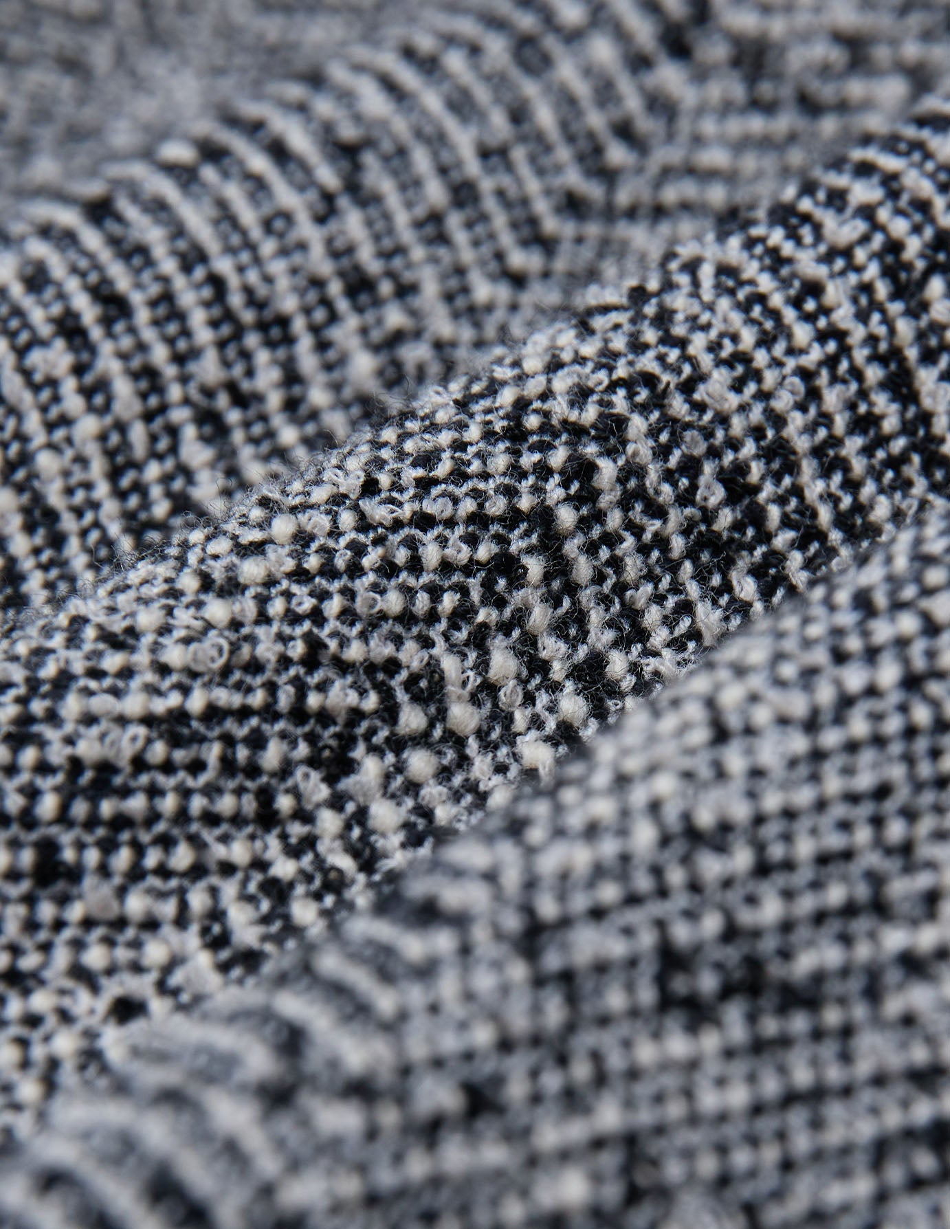 Close-up of the black and white textured herringbone bouclé weave on the Women Ashryn Pants Wide Domino Herringbone.