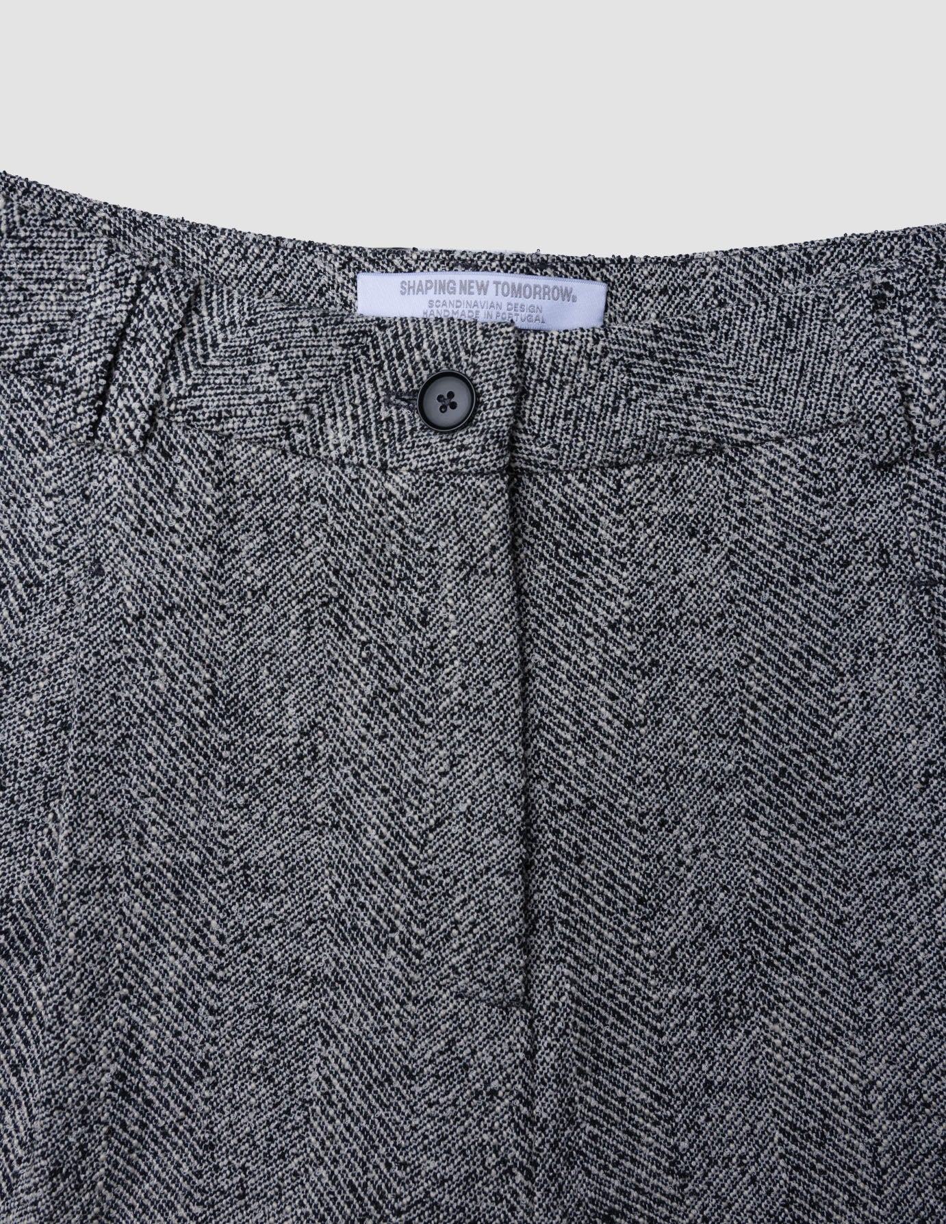 Close-up of the waistband and button closure of Women Ashryn Pants Wide Domino Herringbone in gray and black.