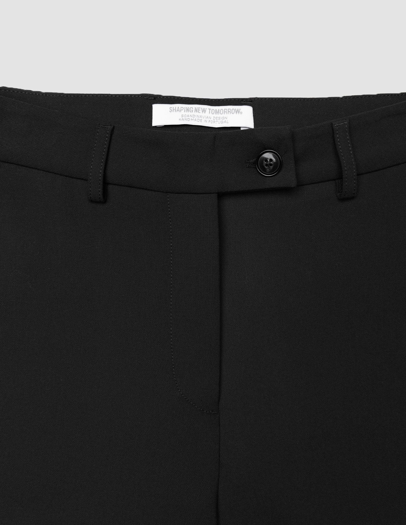 Close-up of the waistband of Women GO2 Pants Straight Black, featuring a single button closure, belt loops, and a high-waisted, straight-leg fit.