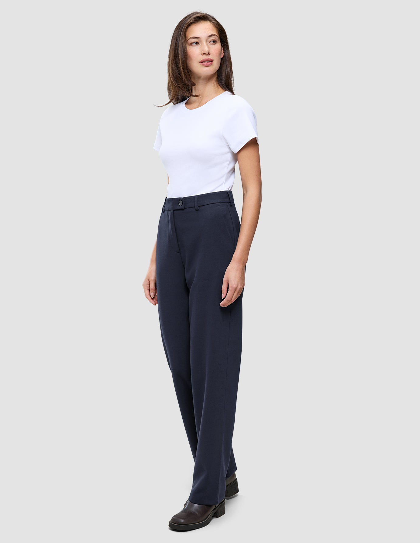 A woman wearing a white t-shirt and Women GO2 Pants Straight Blue Nights.