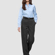 A woman wears a light blue button-down shirt with Women GO2 Pants Straight Dark Grey Melange, featuring a black belt.