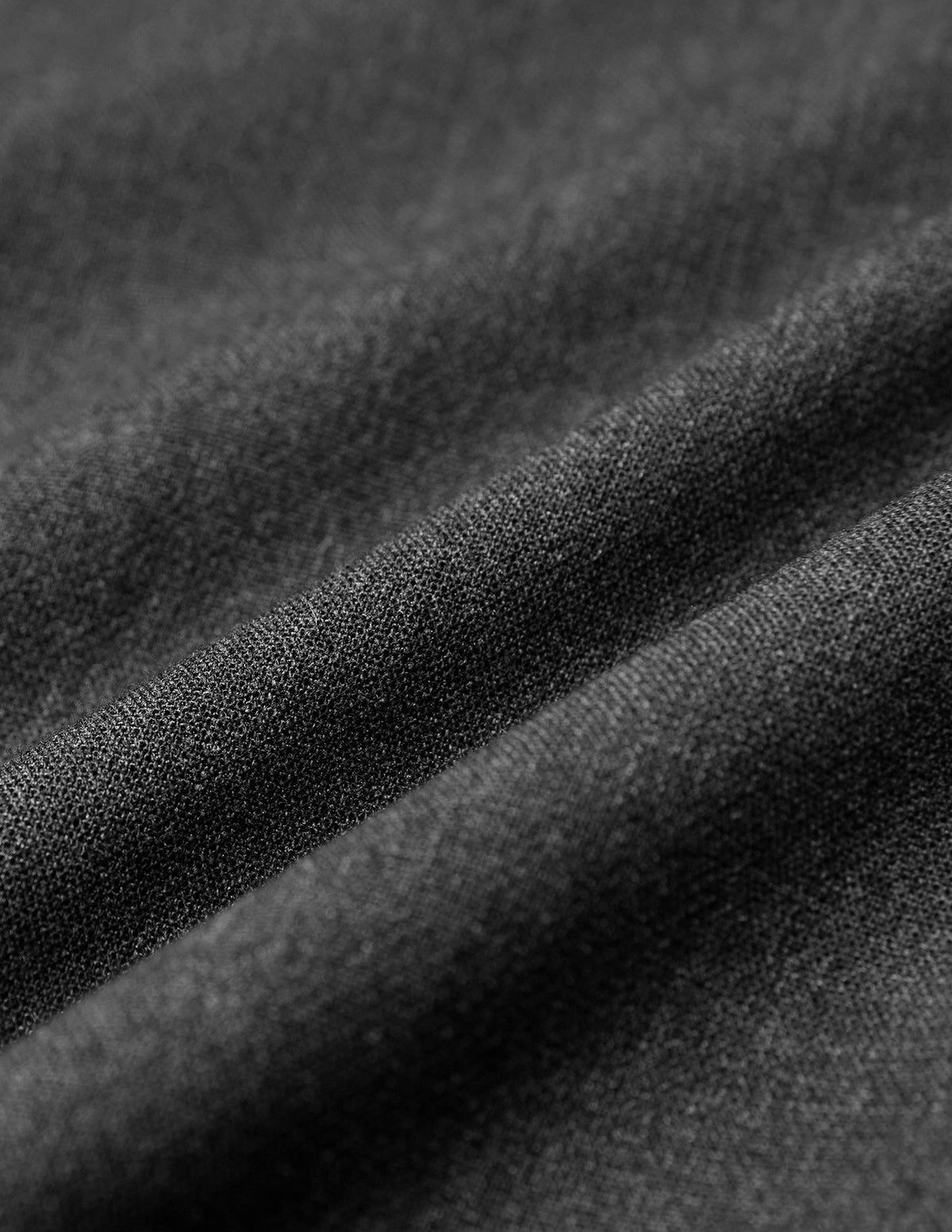 Close-up of Women GO2 Pants Straight Dark Grey Melange, showing draped, dark grey fabric with a visible weave characteristic of Scandinavian design.