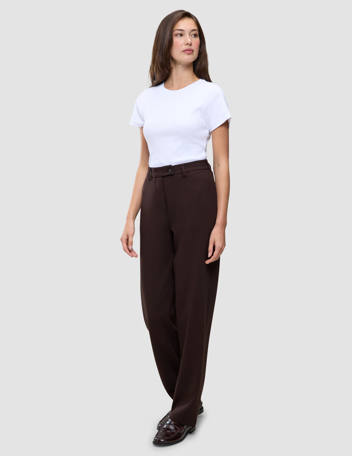 A woman wearing a white t-shirt, Women GO2 Pants Straight Mocha, and loafers.