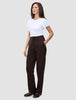 A woman wearing a white t-shirt and Women GO2 Pants Straight Mocha, featuring a high-waisted, straight-leg cut with a button-front waist and side pockets.